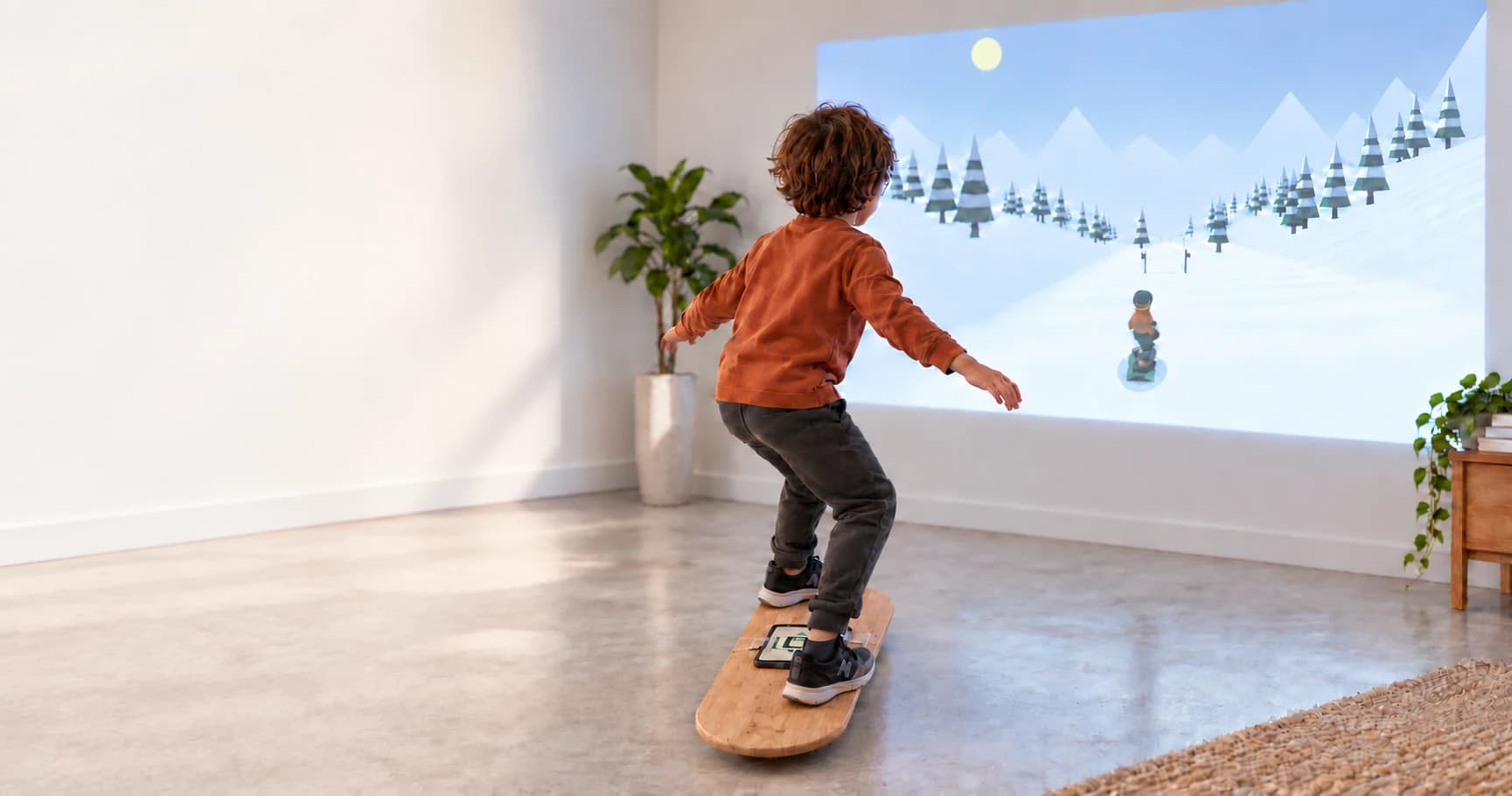 A child balancing on a wooden board with a phone attached, playing snowboarding projected onto a wall.